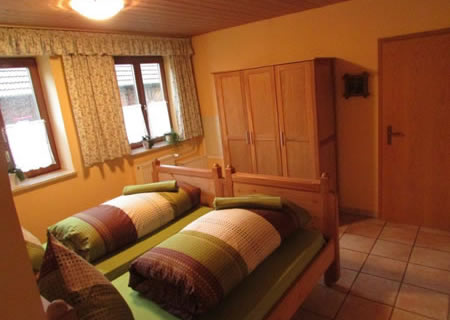 Schlafzimmer mit zwei Holzbetten und Kleiderschrank